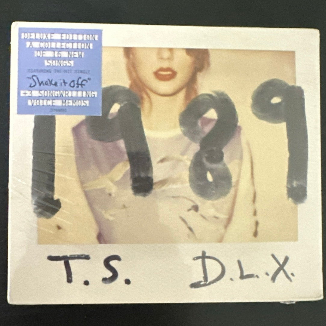 Sealed Taylor Swift 1989 D.L.X. exclusive CD with album cover art and packaging details visible in the image.