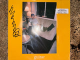 Mac DeMarco orange vinyl LP record with signed cover, featuring the artist's guitar artwork and collectible signed packaging.